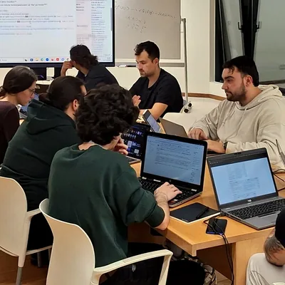 Equipo trabajando con portátiles alrededor de una mesa
